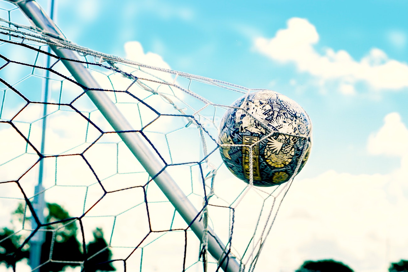 A soccer ball that has just hit the back of the net